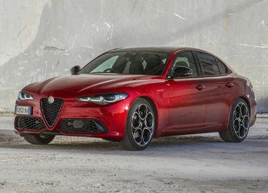 Červený sedan Alfa Romeo Giulia s charakteristickou maskou Scudetto, predný trojštvrťový pohľad