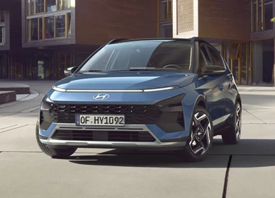 Modrý Hyundai Bayon zaparkovaný na námestí medzi tehlovými budovami