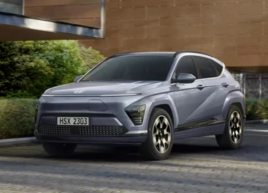 Svetlomodrý Hyundai Kona Electric na príjazdovej ceste pred rodinným domom