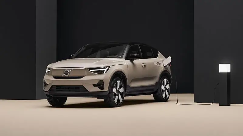 Volvo EC40 v zlatistej farbe spredu s uzavretou maskou elektromobilu – elektrické SUV kupé so škandinávskym dizajnom