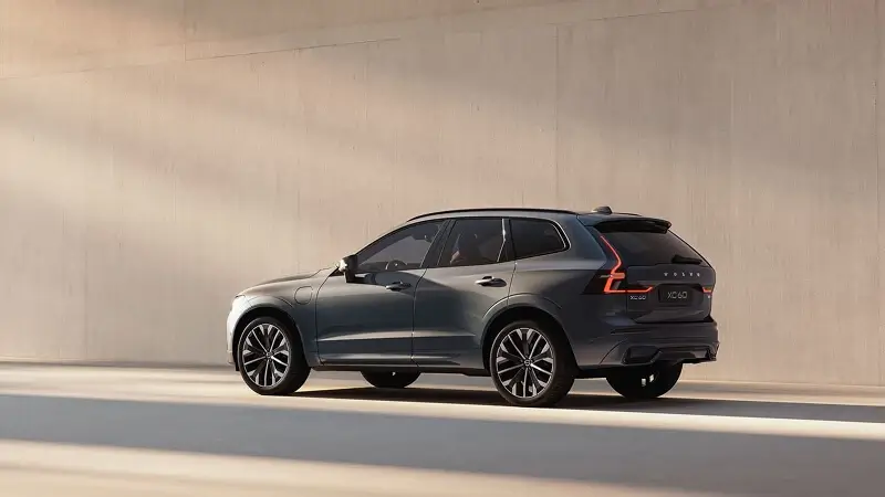 Zadný pohľad na Volvo XC60 v sivej farbe s vertikálnymi LED svetlami – stredne veľké SUV s elektrifikovaným pohonom