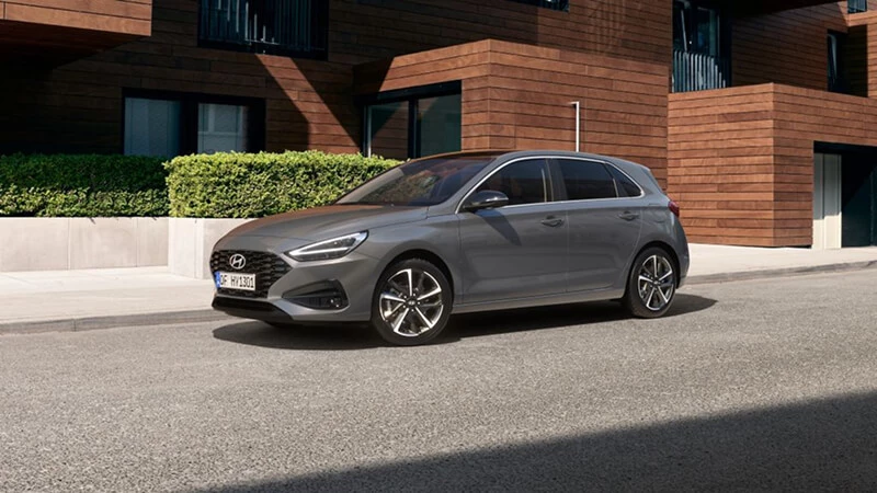 Sivý Hyundai i30 s LED svetlometmi, predný trojštvrťový pohľad na mestskej ulici