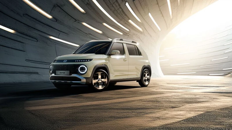 Krémový Hyundai Inster so strešnými lyžinami v osvetlenom betónovom tuneli