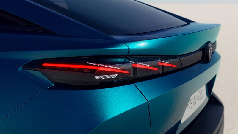 Detail zadných LED svetiel Peugeot 408 s červenými pazúrmi na splývavej zádi kupé