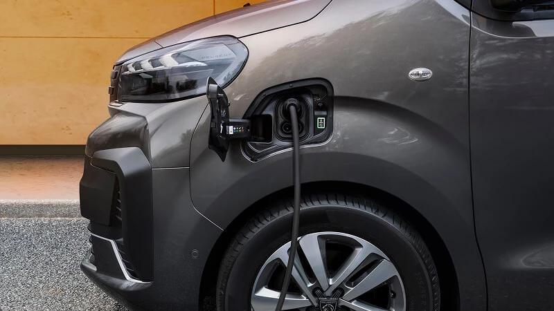 Detail nabíjacieho konektora Peugeot E-Traveller – kábel zapojený v prednom blatníku elektrického minibusu